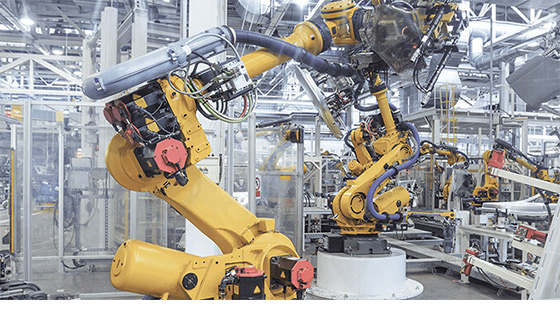A yellow industrial robot in an industrial hall
